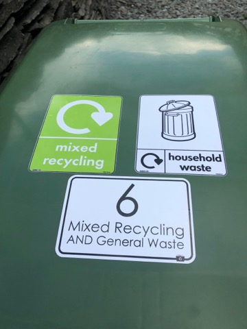 Close-up of the recycling and household waste stickers on the bin lid